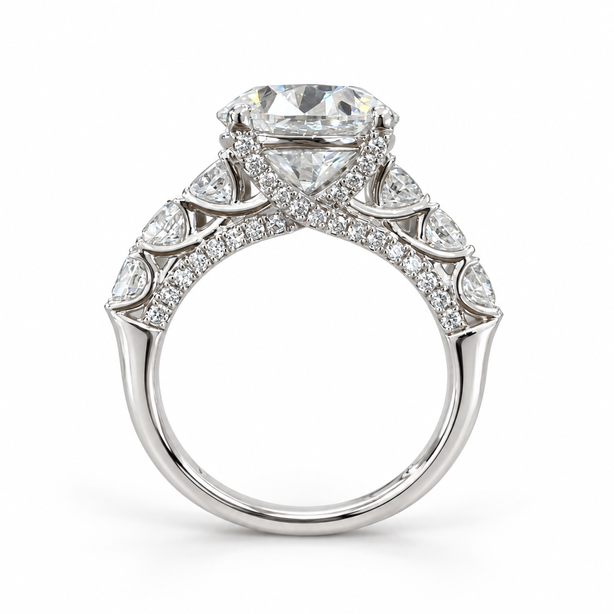 Make a statement from every angle. This engagement ring features a 5 carat round lab-grown center diamond framed by larger diamonds along the shoulders. Delicate diamonds beneath the center and along the sides of the band add detail to its striking profile. Crafted in 14K white gold, the ring has a total diamond weight of 6 5/8 carats.